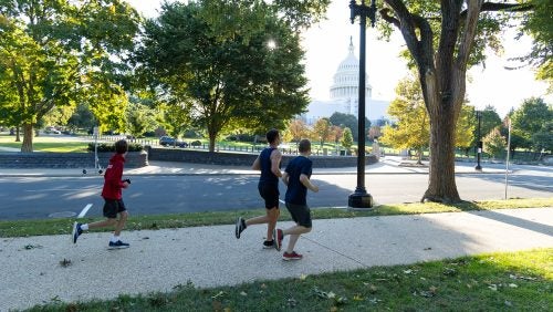 Participants in a reunion fun run jog past the U.S. Capitol