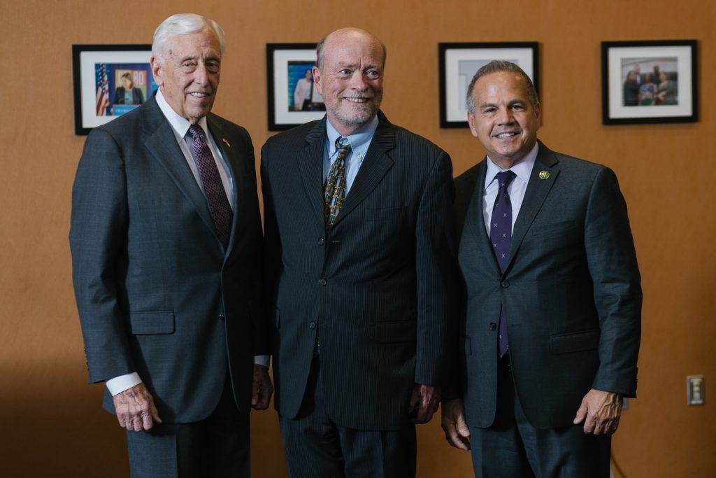 Three men standing together and smiling