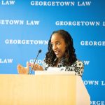 A woman gesturing at a podium