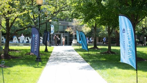 A campus walkway with Welcome flags along it