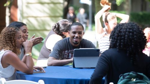 Several students sitting at an outdoor table