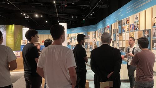 A group of people at a museum listening to a tourguide