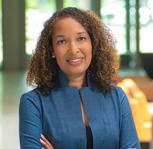 Image of a Black woman with curly hair wearing a blue jacket