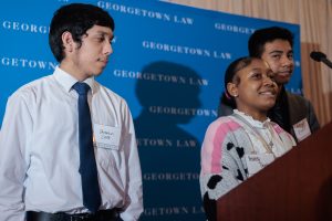 Three teenagers standing at a podium