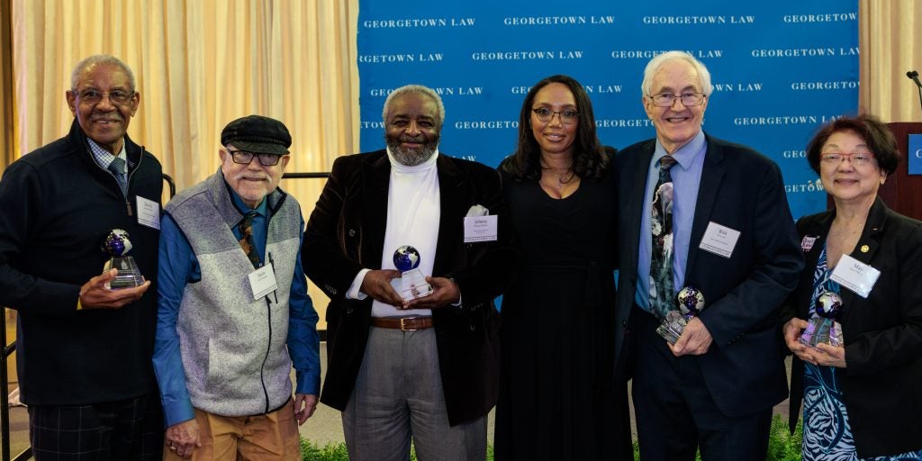 Six people standing together to pose for a photo at a Georgetown Law reception celebrating the Street Law program
