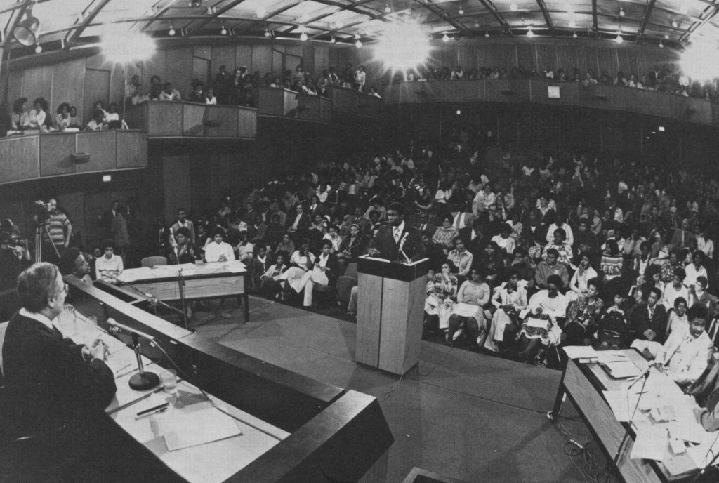 A black and white image of an auditorium at Georgetown Law, where high school students are participating in a moot court competition