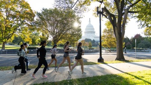 A line of people jogging past the U.S. Capitol building