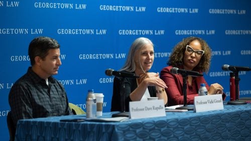 Three professors sitting in a row, speaking on a panel