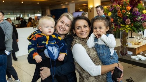 Two women, each holding toddlers