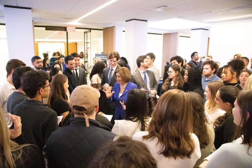 A group of students standing in a circle, with former U.S. House Speaker Nancy Pelosi standing in the center.