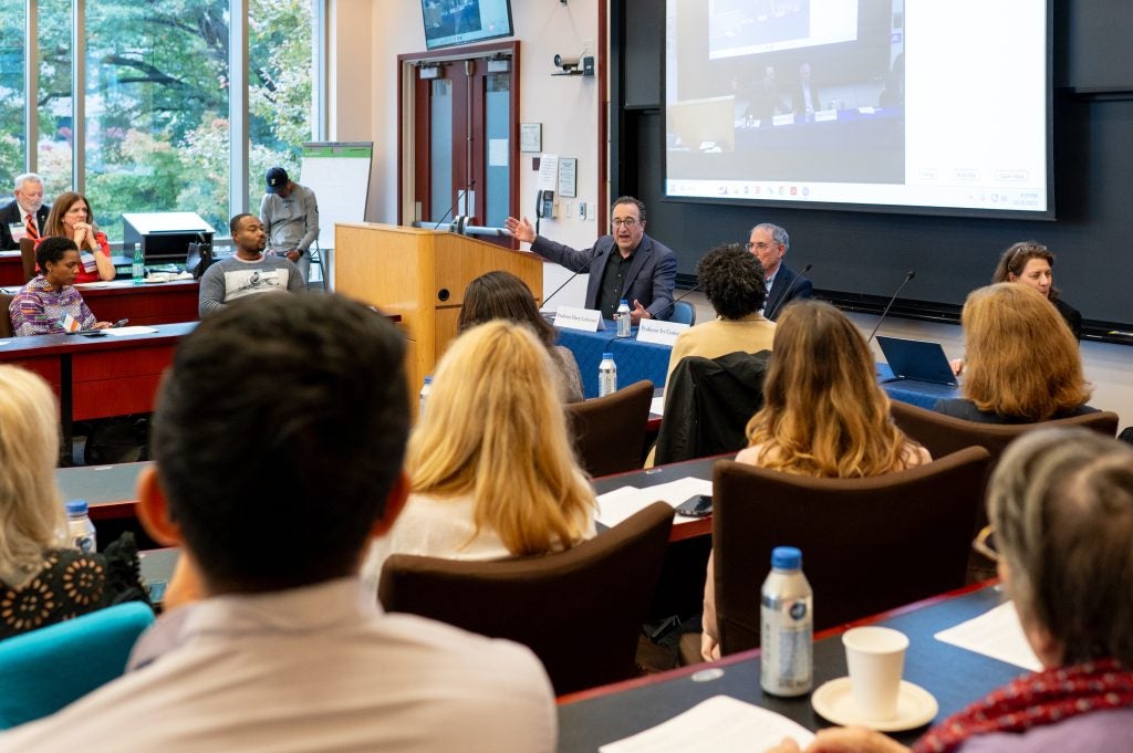 Two professors speaking to a classroom of alumni