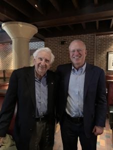 two men standing together and smiling