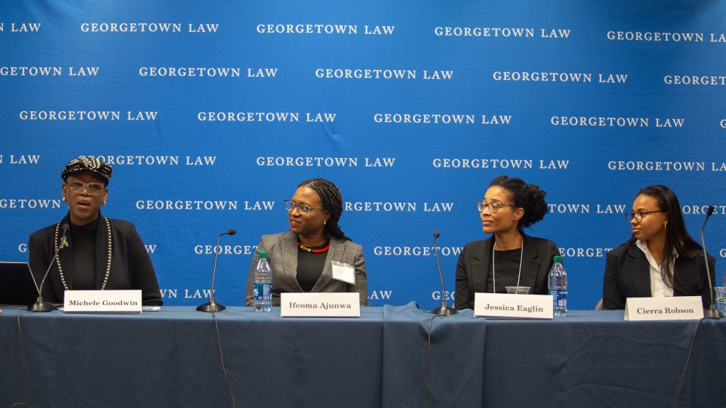 Four Black women speaking on a panel in front of a Georgetown Law backdrop