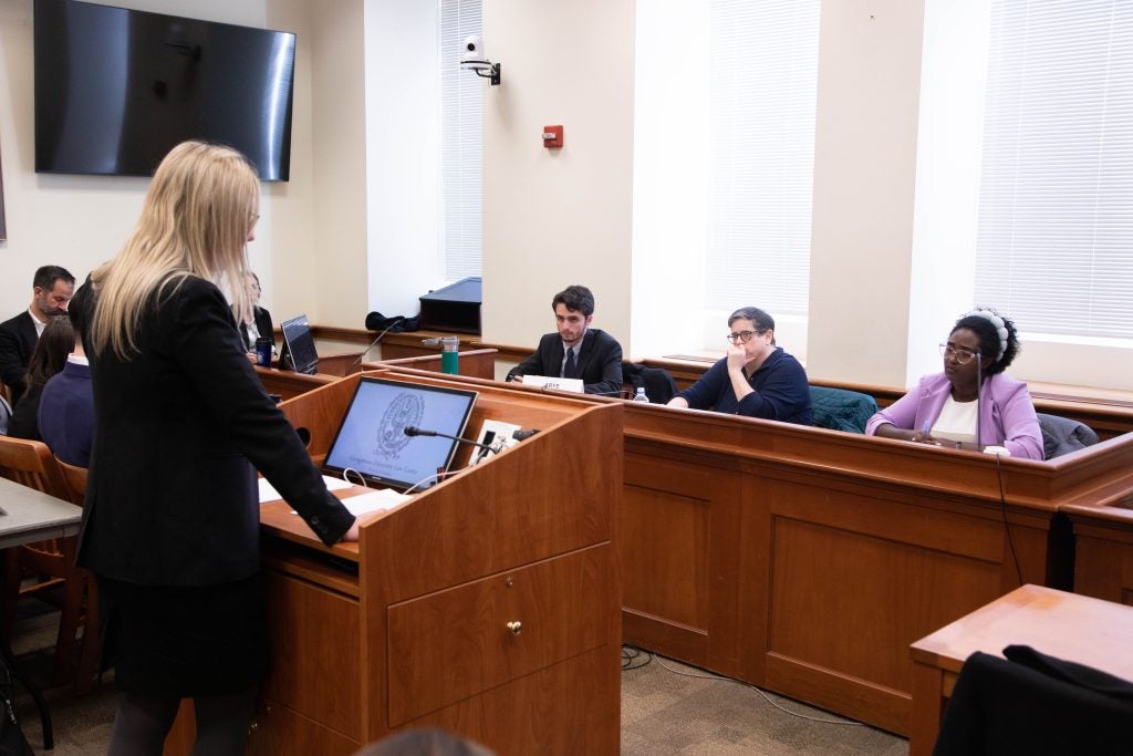 A student addresses the teaching fellows and guest judge posing as members of the European Court of Human Rights.