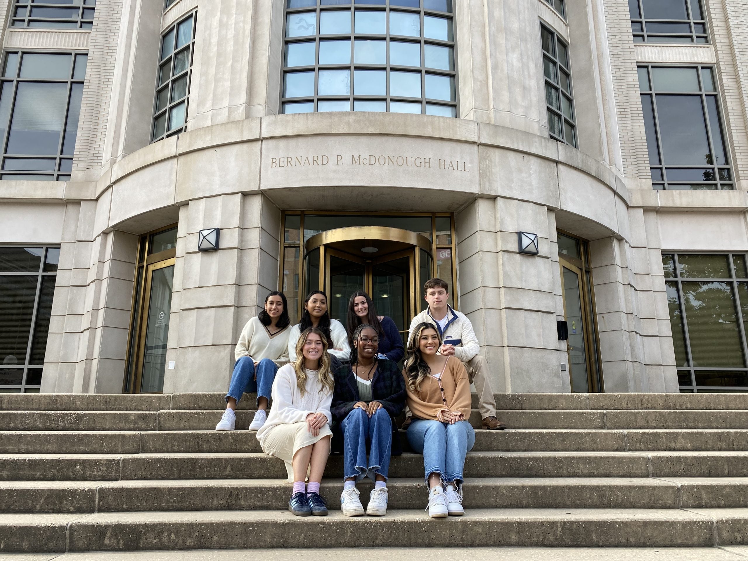 Student interns sitting on the footsteps of McDonough Hall