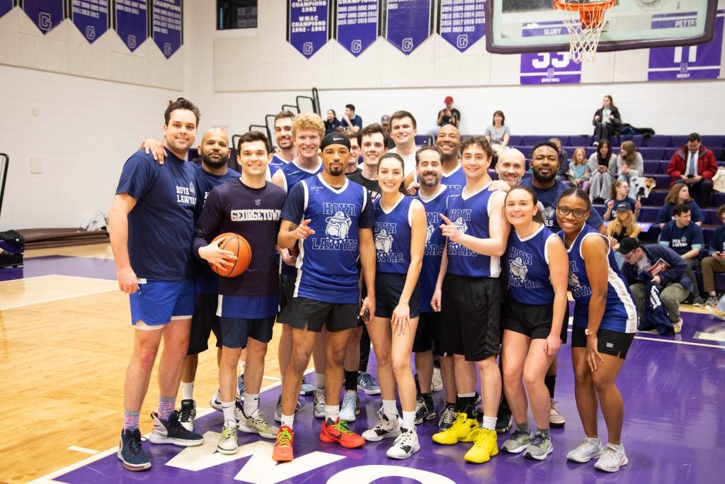 A group of Georgetown Law professors, students and staffers wearing basketball uniforms