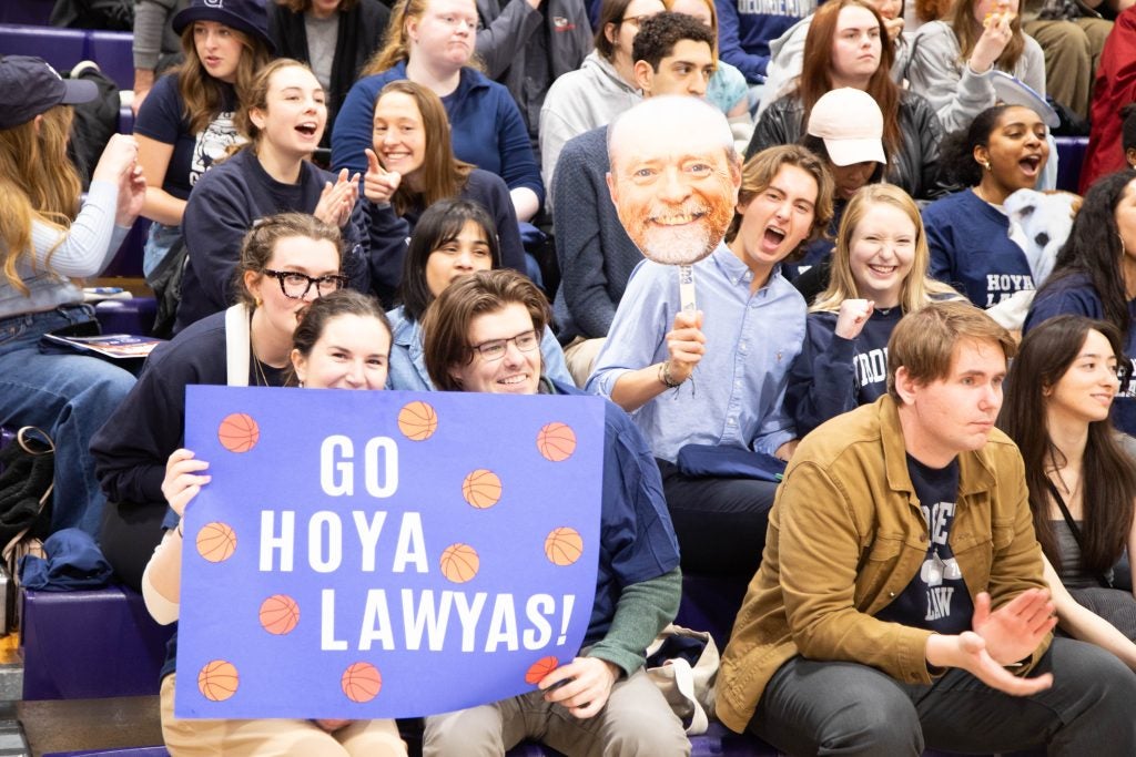The spectators at the Home Court basketball game, holding signs