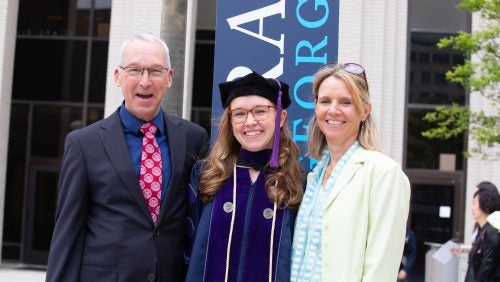 An LL.M. graduate and her parents pose for a photo.