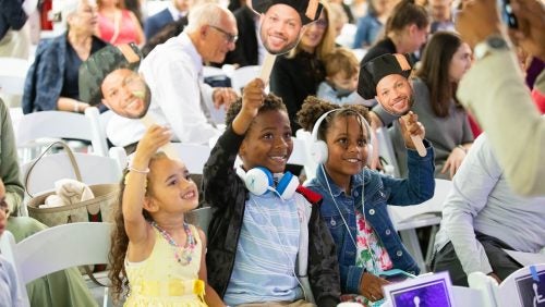 Three children cheer in the audience.