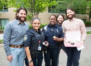 A picture of the Osbornes sharing cupcakes with campus safety department employees to celebrate their last day of classes.