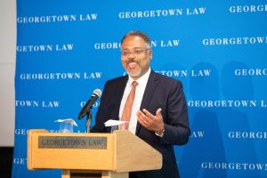 A bearded man speaking at a podium