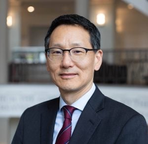 A head shot of a man with short dark hair and glasses