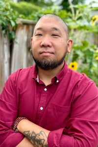 Pierce Suen headshot in a red shirt.
