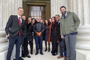 Prof. Brian Wolfman (center, in black jacket) and Madeline Meth L'17 (center, in purple dress) pose with members of the Appellate Immersion Clinic following oral argument at the U.S. Supreme Court.