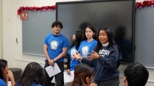Early Outreach Initiative volunteer Heaven Johnson-Branch, L'24, leads Bryant High students in a mock lawsuit activity. 