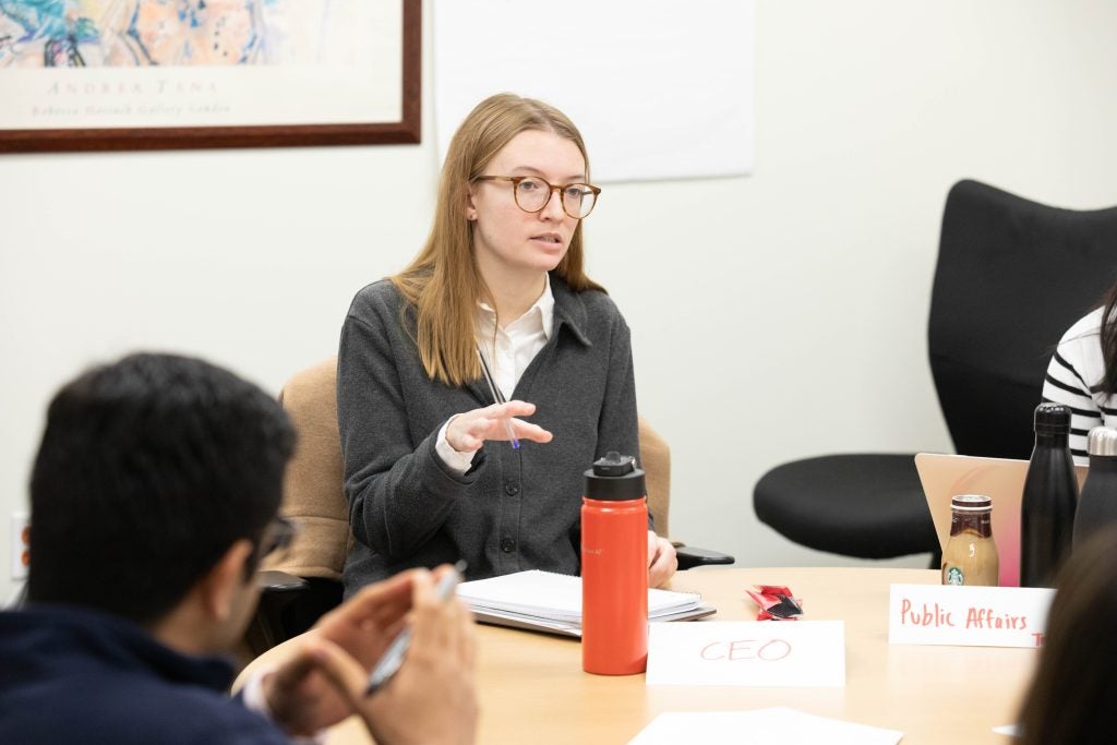 Clare Ulmer, L’27, talks to her classmates during the capstone course simulation.