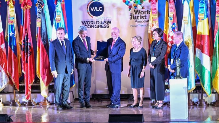 A person receiving an award on stage surrounded by other people
