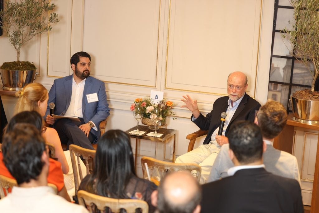 Two men speaking to a room of people