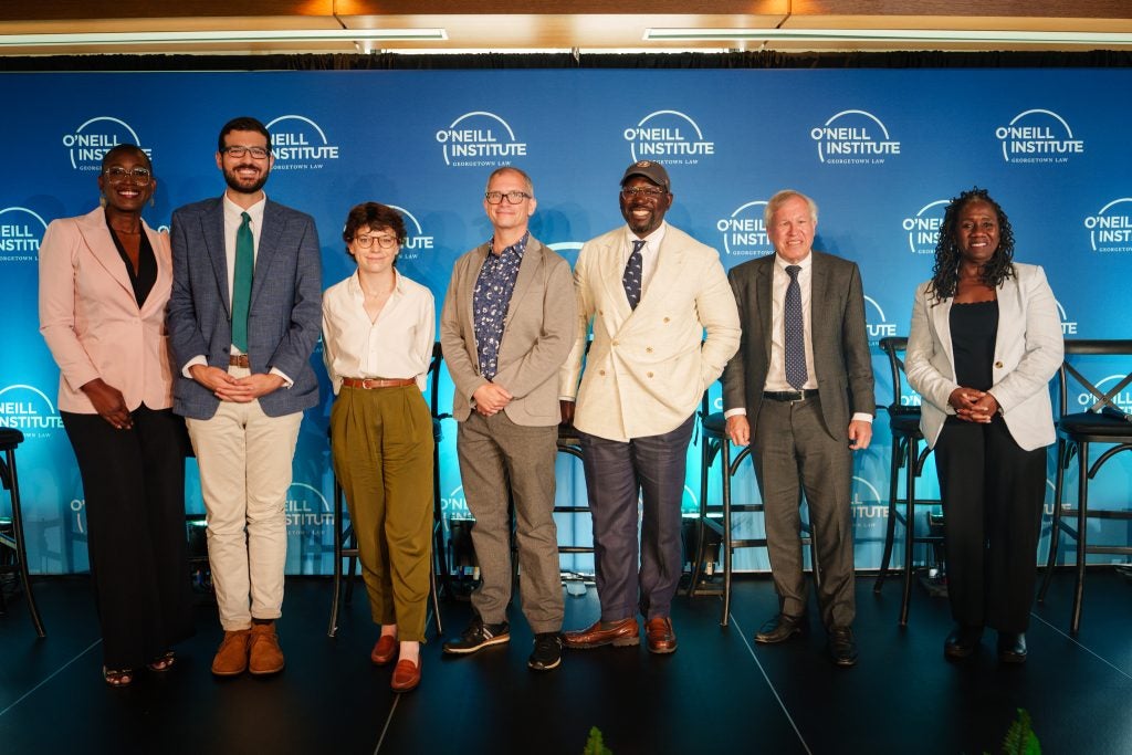 Panelists pose onstage for a group photo following the event.