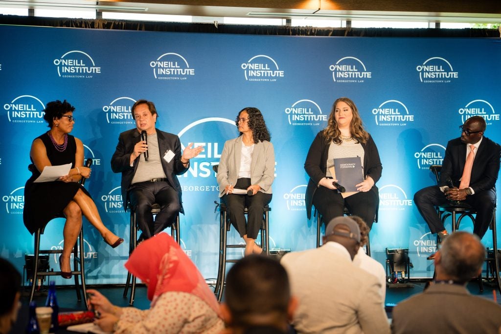 A group photo of panelists onstage.