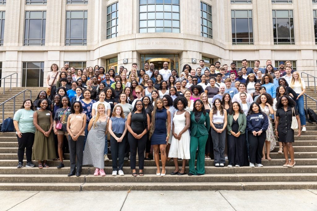 A large group of students posing on the steps of McDonough Hall