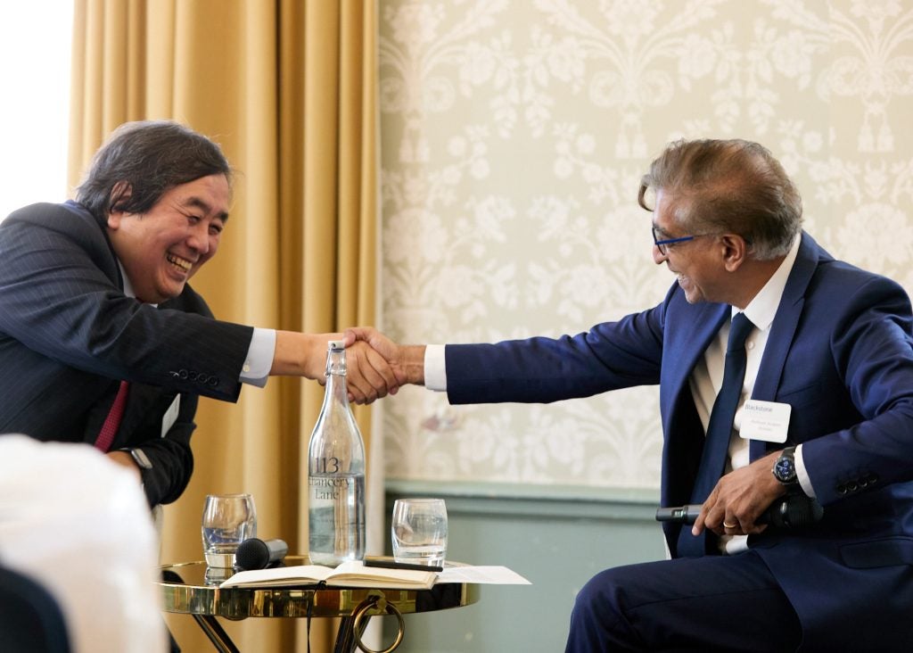 Two men smiling and shaking hands