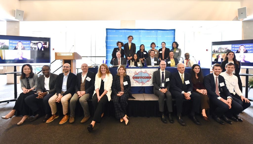 A group photo of people, including several on a video screen