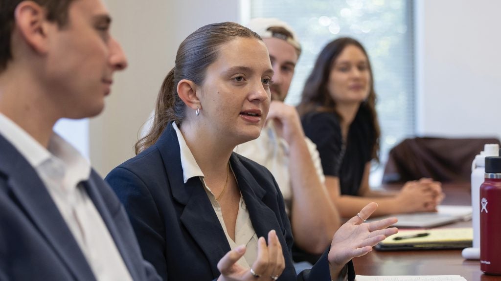 A law student speaking in class, with other students listening