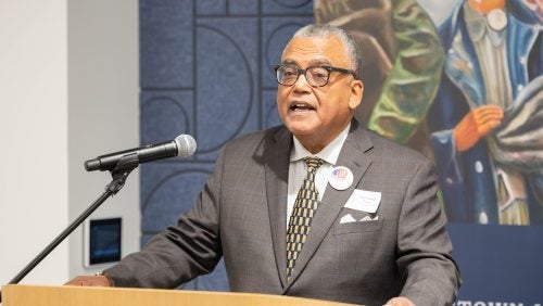 A man in a suit standing at a podium