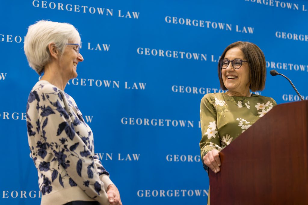 Two women standing and smiling at each other
