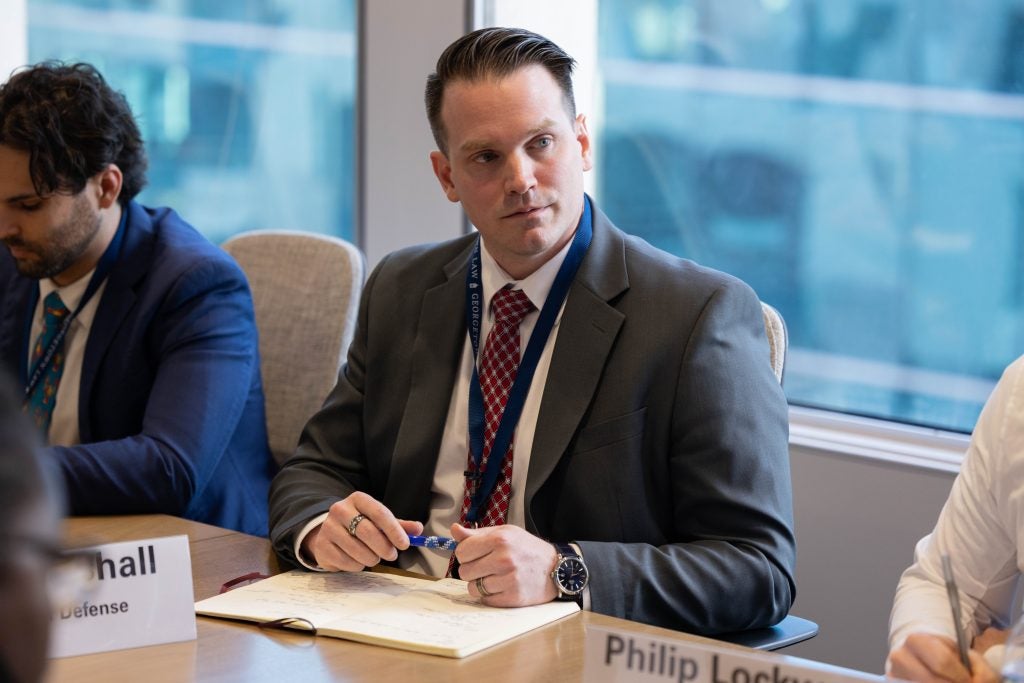 Student Chris Marshall sits at a briefing table, listening intently. 