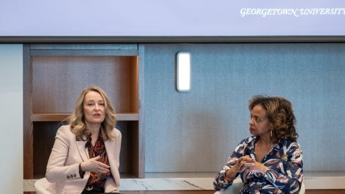 Two women sit in front of the room to lead a breakout session.
