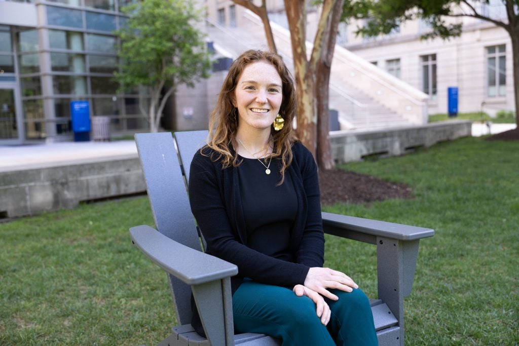 Portrait of a woman sitting on a lawn chair on the campus green and smiling