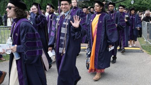 Students in regalia walking.