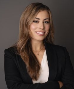 Headshot of Lauren, smiling, wearing a black jacket and white shirt