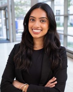 Headshot of Adithi, wearing a black suit and smiling