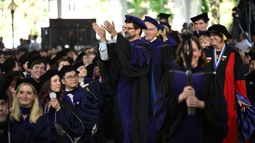 Faculty in regalia process into the ceremony.