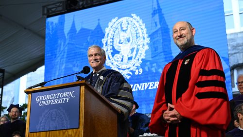 Two men in regalia stand at a podium.