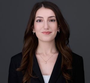 Headshot of Sofia, wearing a black jacket and smiling