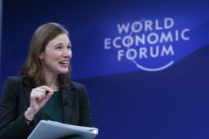 A woman in front of a backdrop reading WORLD ECONOMIC FORUM